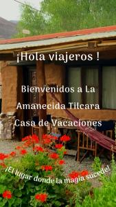 a sign on the side of a building with red flowers at La Amanecida Tilcara in Tilcara