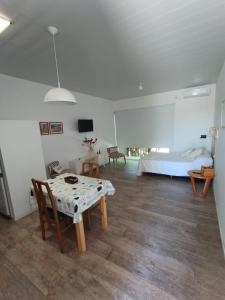 a living room with a table and a bed at RCH Capri in Chacabuco