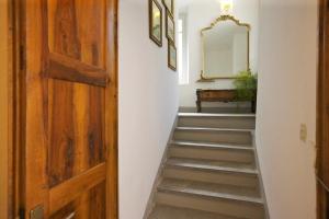 a stairway with a wooden door and a mirror at Casa Maria Vittoria in Cannero Riviera