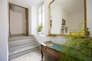 a hallway with a mirror and a table and stairs at Casa Maria Vittoria in Cannero Riviera +23 photos
