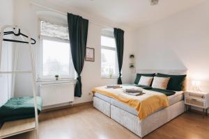 a bedroom with a bed and two windows at Heideblick Apartment Dresden WIFI Netflix in Dresden