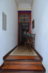 um corredor com uma mesa e uma cadeira num quarto em Pousada Guignard em Ouro Preto