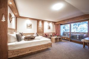 a bedroom with a bed and a large window at Brunnenhof Oberstdorf - Ferienwohnungen mit Hotel Service in Oberstdorf +116 photos