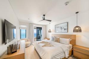a white bedroom with a bed and a ceiling fan at Allure 301 condo in Bridgetown