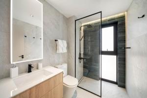 a bathroom with a toilet and a glass shower at Allure 301 condo in Bridgetown