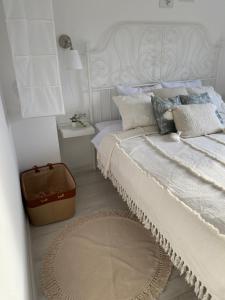 a white bedroom with a bed with a white headboard at Vikendica Fruška lipa in Čortanovci +87 photos