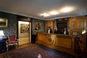 里斯本Pestana Palace Lisboa Hotel & National Monument - The Leading Hotels of the World的一间设有酒吧的审判室,后面有两个人 更多37张照片
