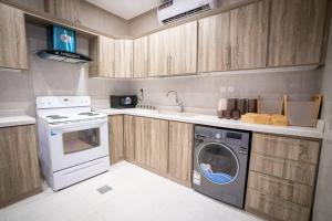 a kitchen with a washing machine and a stove at 005 - Saudi - Elegant apartment in Riyadh (Noor) in Al Hofuf