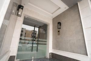 a bathroom with a glass shower with a mirror at 005 - Saudi - Elegant apartment in Riyadh (Noor) in Al Hofuf