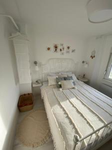 a white bedroom with a large bed in a room at Vikendica Fruška lipa in Čortanovci