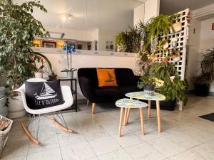 een woonkamer met een bank en twee tafels bij hotel l'échappée d'oléron in Saint-Georges-dʼOléron