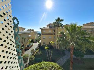 a view of a building with palm trees and buildings at Apartamento en zona Cabopino in Marbella