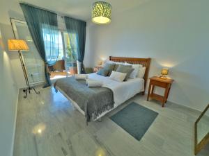 a bedroom with a large bed and a couch at Apartamento en zona Cabopino in Marbella +31 photos