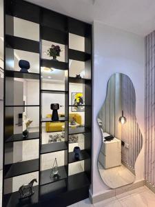 a room with a wall with black and white shelves at Cozy one bedroom apartment in Abuja