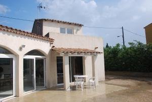 a house with a table and chairs in front of it at Soleil De Camargue in Le Sambuc