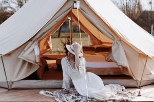 a woman sitting in front of a tent at Boho Zelt Lebenshofalpakas in Ziemetshausen