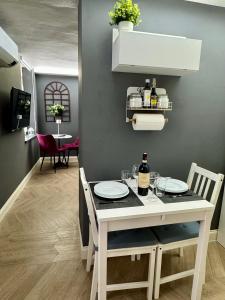 a dining room with a table with plates and a bottle of wine at Chagall Bijoux in Asti