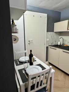 a small kitchen with a table with a bottle of wine at Chagall Bijoux in Asti