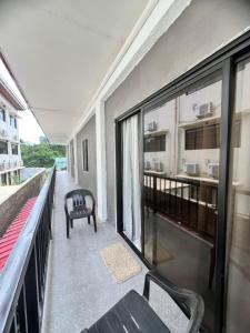 a balcony of a building with a bench and a kitchen at Xavier's Place Coron in Coron