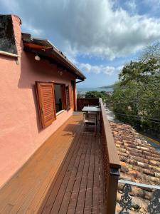 a wooden deck on the side of a house at Apartamento Charmoso com vista para o mar in Ilhabela