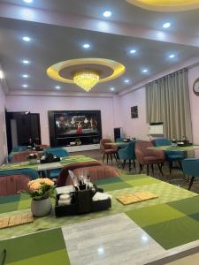 a dining room with tables and chairs and a television at Hotel Buddha International in Patna