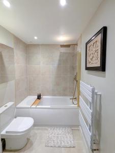a bathroom with a white tub and a toilet at Rossetti Retreat in Birchington +17 photos