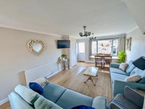 a living room with two blue couches and a table at Rossetti Retreat in Birchington
