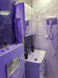 a purple bathroom with a sink and a mirror at New and modern appartament in Greece in Paralia Katerinis