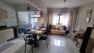 Una cocina y una sala de estar con mesa y sillas. en Apartamento no Tombo 30 metros da praia, en Guarujá