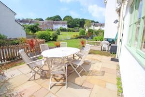 a patio with a white table and chairs at Green Cottage in Porthmadog