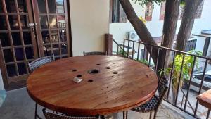 福塔莱萨Meu Canto hospedagem的阳台上的木桌,周围摆放着椅子