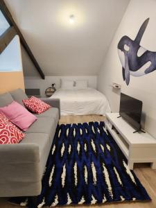 een woonkamer met een bank en een bed bij Studio downtown, proche ville close, Wifi in Concarneau