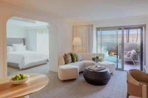 a hotel room with a bed and a living room at Regent Santa Monica Beach by IHG in Los Angeles