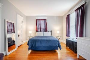a bedroom with a bed and two windows at Welcome to Hat City Danbury, A Suburban Retreat in Danbury