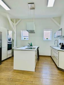 a kitchen with a white island in a room at Wohnung im Zentrum von Neuss - Estia Living in Neuss