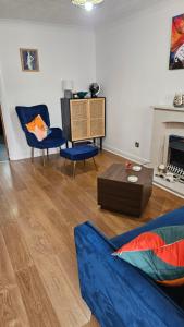 a living room with a blue couch and two chairs at Florence house in Thornaby on Tees