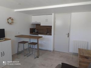 a kitchen with white cabinets and a table and chairs at Studio entrée indépendante idéal vacance ou travail in Istres