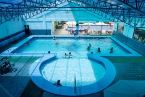 a large swimming pool with people in the water at Hostería El Prado in Ibarra