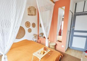 Un dormitorio con una cama naranja y una mesa en Bali Room - Romantic Escape, en Haubourdin
