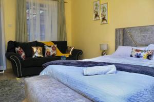 a bedroom with two beds and a couch at The Cozy Cranny, Kamakis in Ruiru