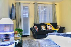 a living room with a couch and a tv at The Cozy Cranny, Kamakis in Ruiru