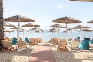 a group of chairs and umbrellas on the beach at Vergos Hotel in Vourvourou