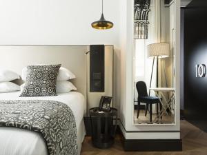 una camera con letto, sedia e specchio di Corso 281 Luxury Suites a Roma