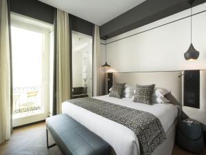 a bedroom with a large bed and a large window at Corso 281 Luxury Suites in Rome