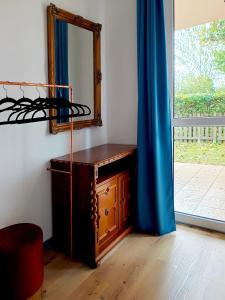 a mirror and a dresser in a room at Sunset Green Apartman in Bük