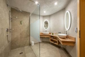 Un baño con dos lavabos y una ducha de cristal. en Villa Heimatliebe, en Ramsau im Zillertal 28 fotos más