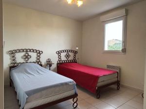 una camera da letto con due letti e una finestra di Maison 4 pièces, Garage, Proche Plage - FR-1-225C-155 a Banyuls-sur-Mer