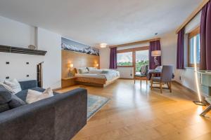 una sala de estar con un sofá y una cama en Villa Heimatliebe, en Ramsau im Zillertal
