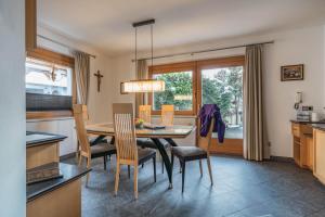 Una cocina y un comedor con mesa y sillas. en Villa Heimatliebe, en Ramsau im Zillertal