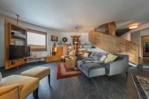 Una sala de estar con un sofá y un televisor. en Villa Heimatliebe, en Ramsau im Zillertal